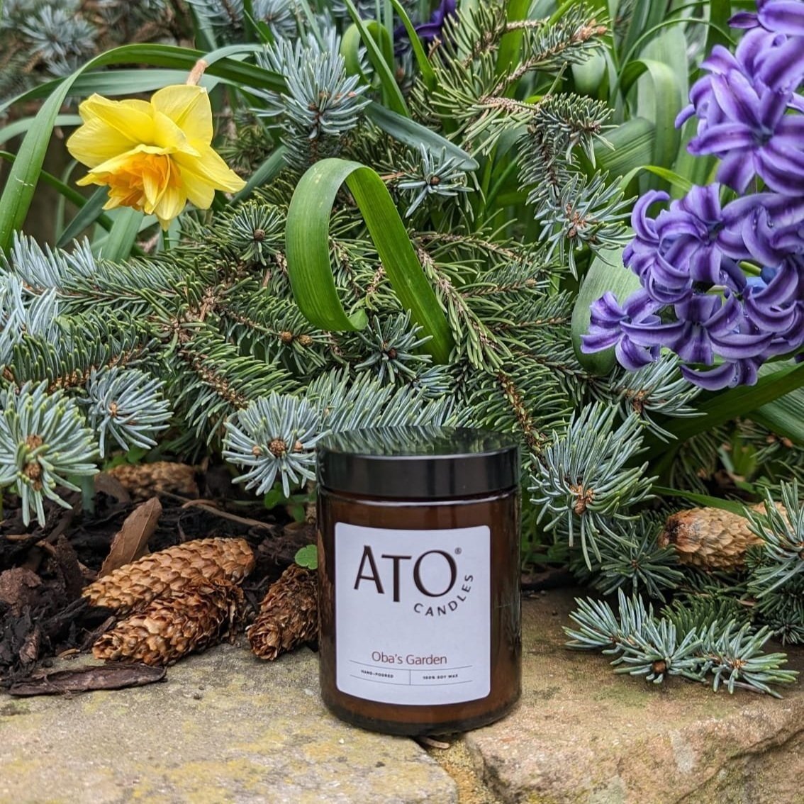 Oba's Garden soy candle in a spring garden